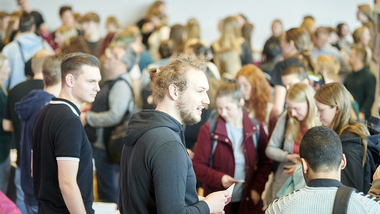 Zahlreiche Menschen in einer Halle und an Infoständen