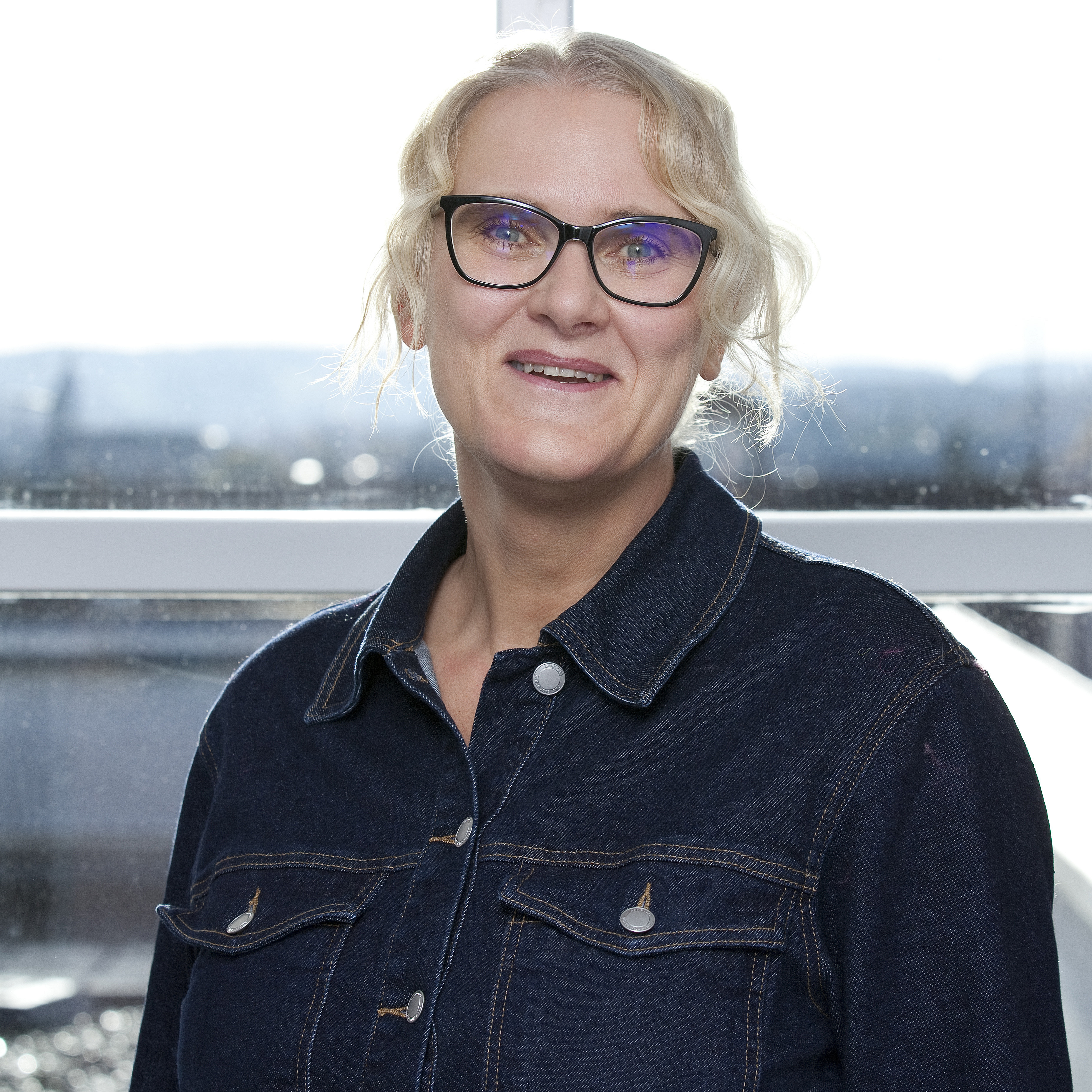 Portrait of a woman with glasses and blonde, pinned up hair