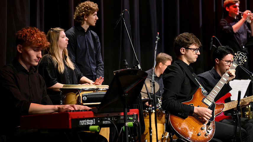 Nahaufnahme mehrerer Musiker an verschiedeneen Instrumenten