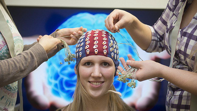 One person with electrode cap, two people connect the cables