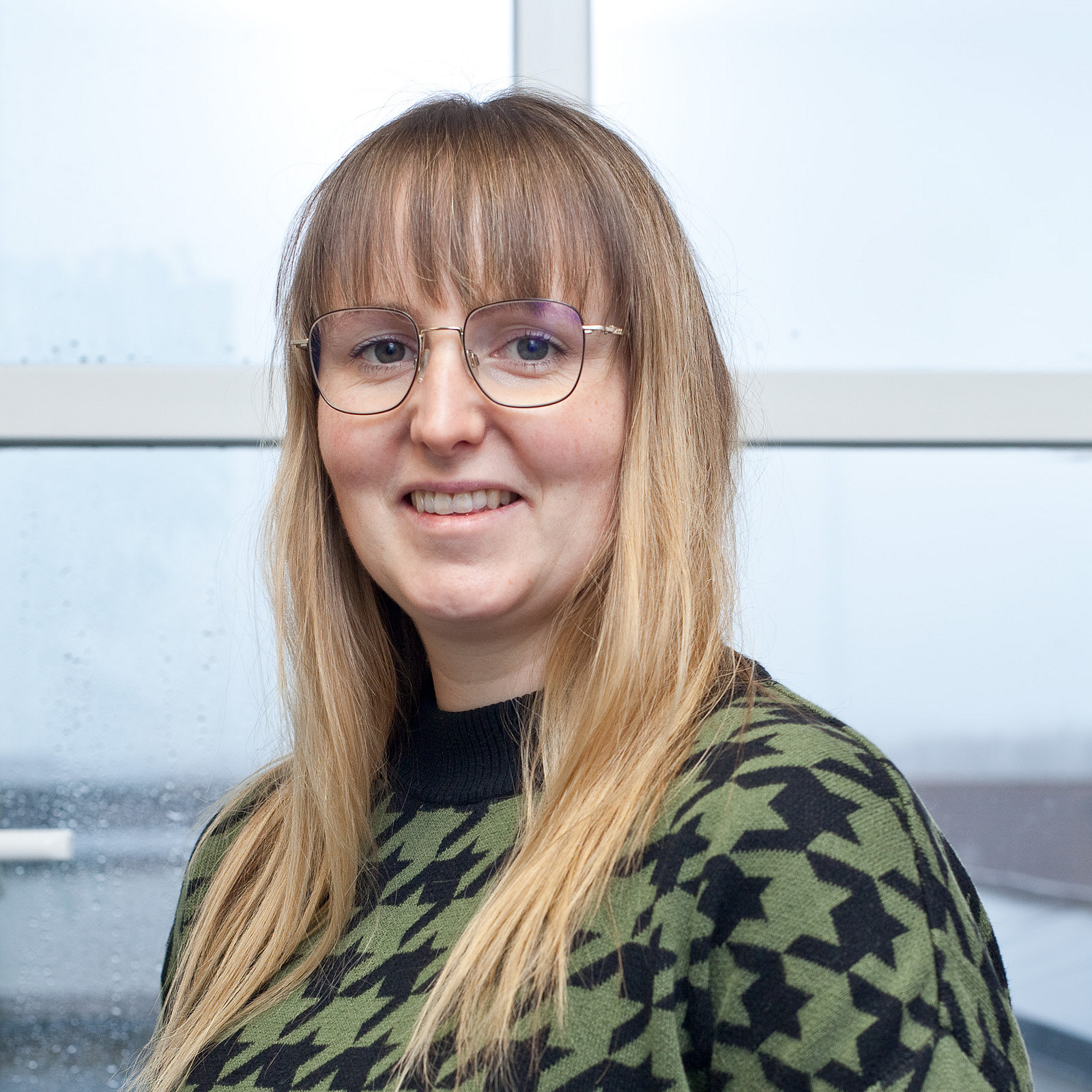 Portraitfoto einer Frau mit langem Haar und Brille