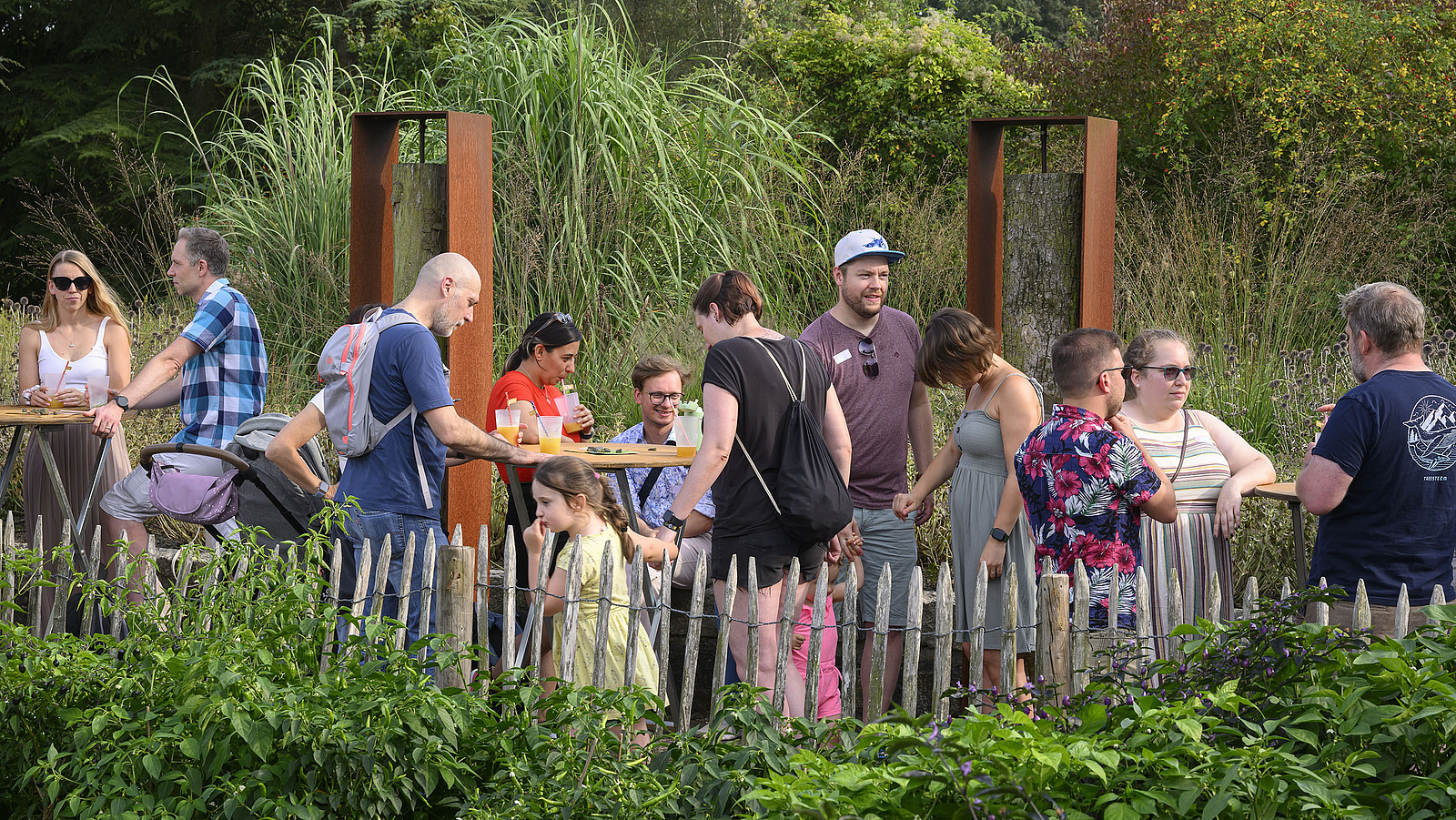 Mehrere fröhliche Personen bei einer Gartenparty.