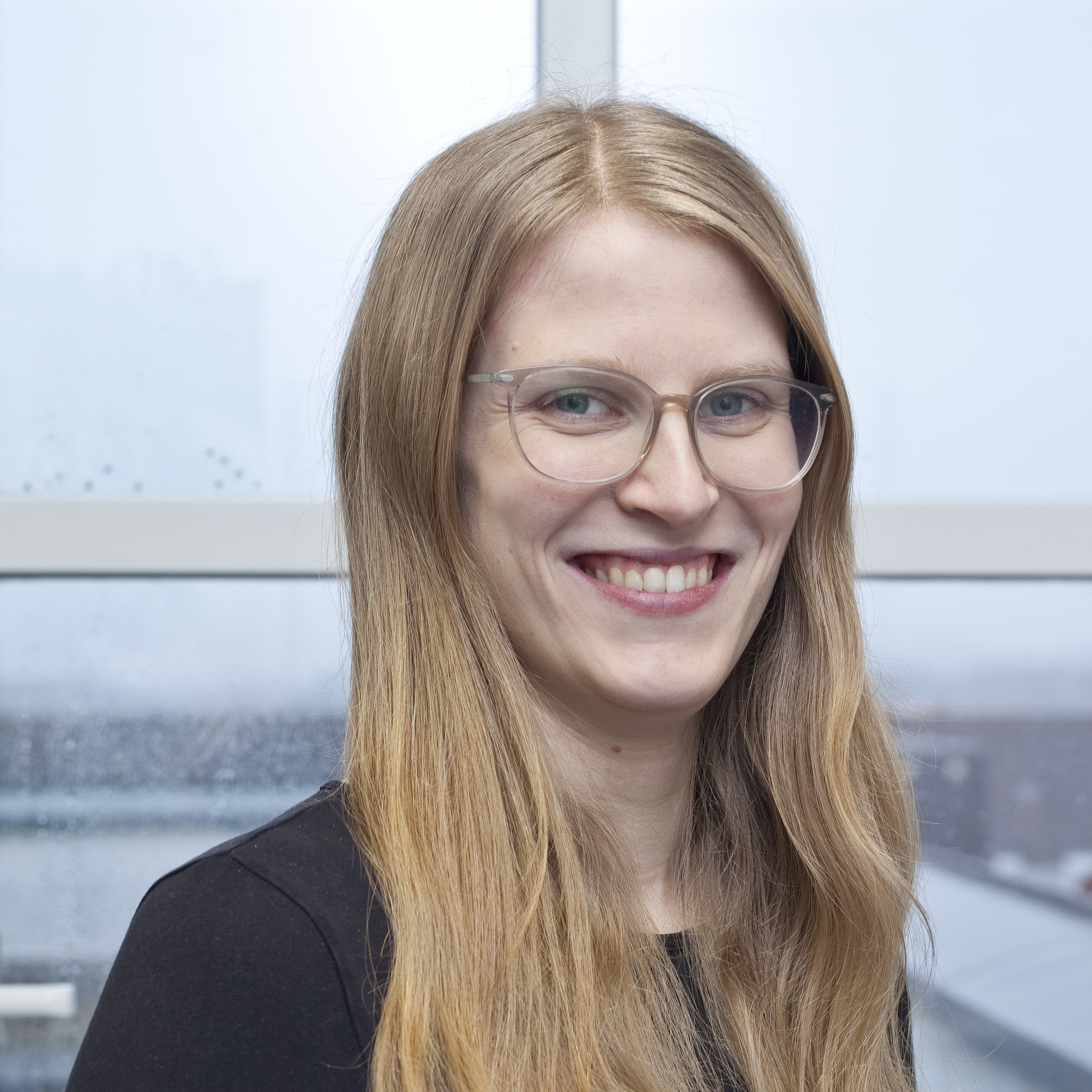 Portrait of a woman with long, blond hair and glasses