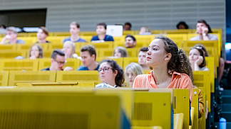 Blick über die Sitzreihen in einem Hörsaal auf Studierende.