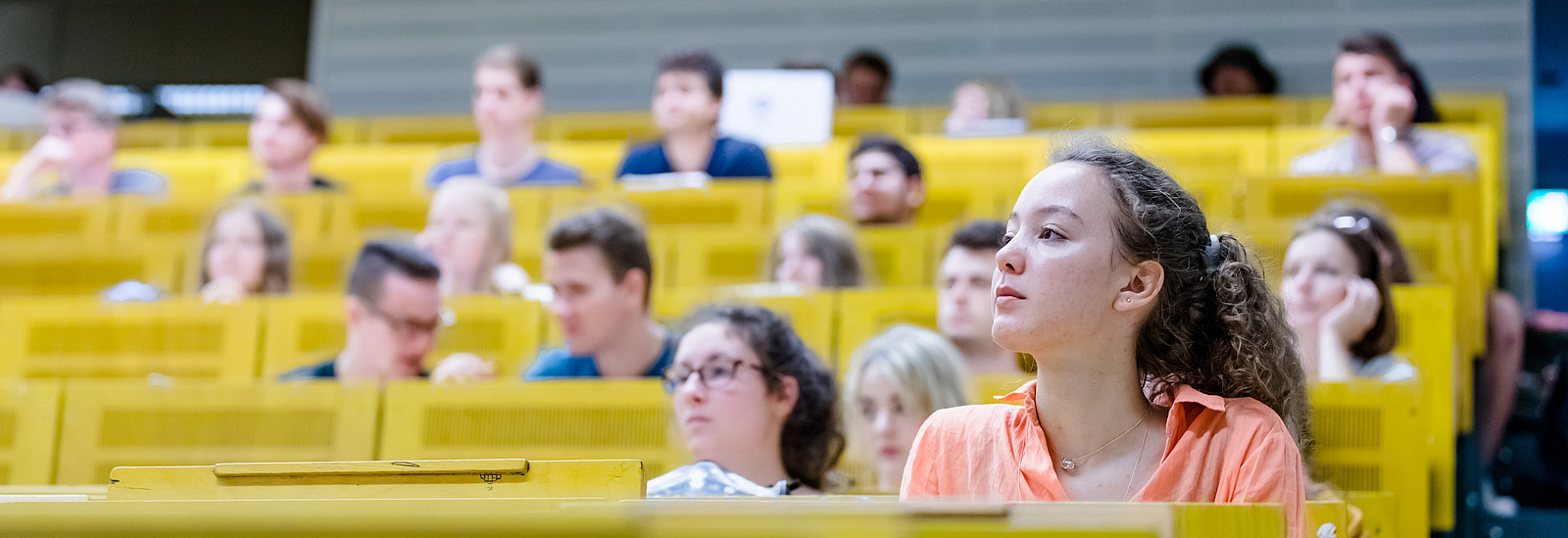 View of students across the rows of seats in a lecture hall.