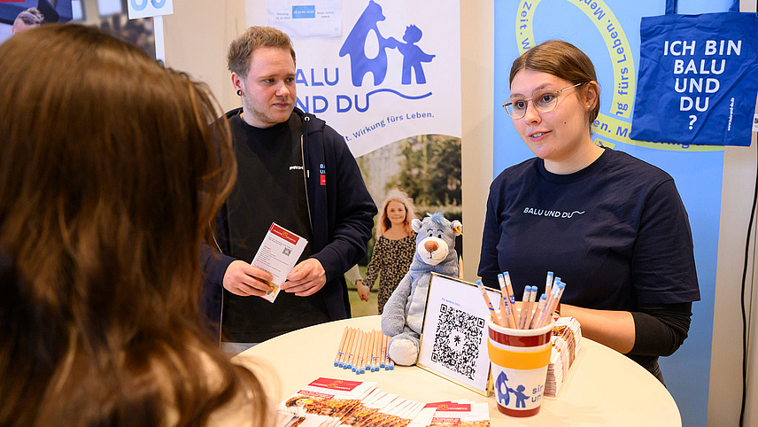 Mehrere Personen an einem Infostand