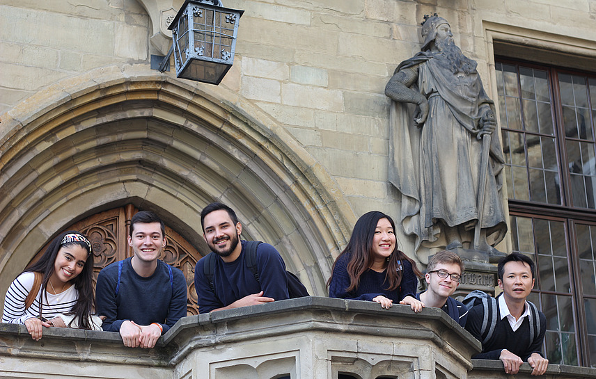 Six international students pose for a photo on the steps of Osnabrück Town Hall.