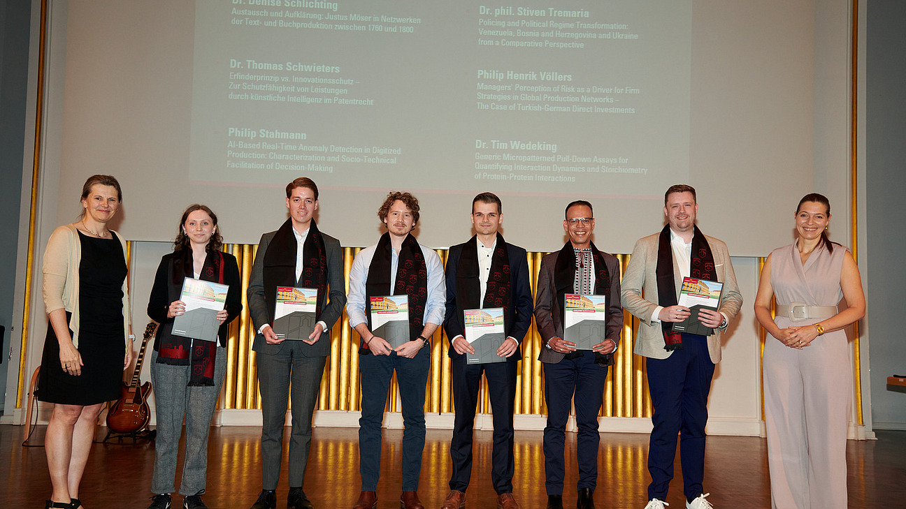 Gruppenfoto der Promovierten auf der Bühne der Schlossaula