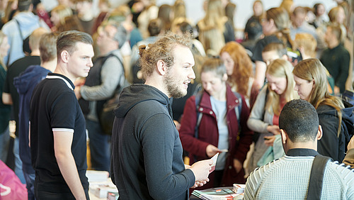 Zahlreiche Menschen in einer Halle und an Infoständen