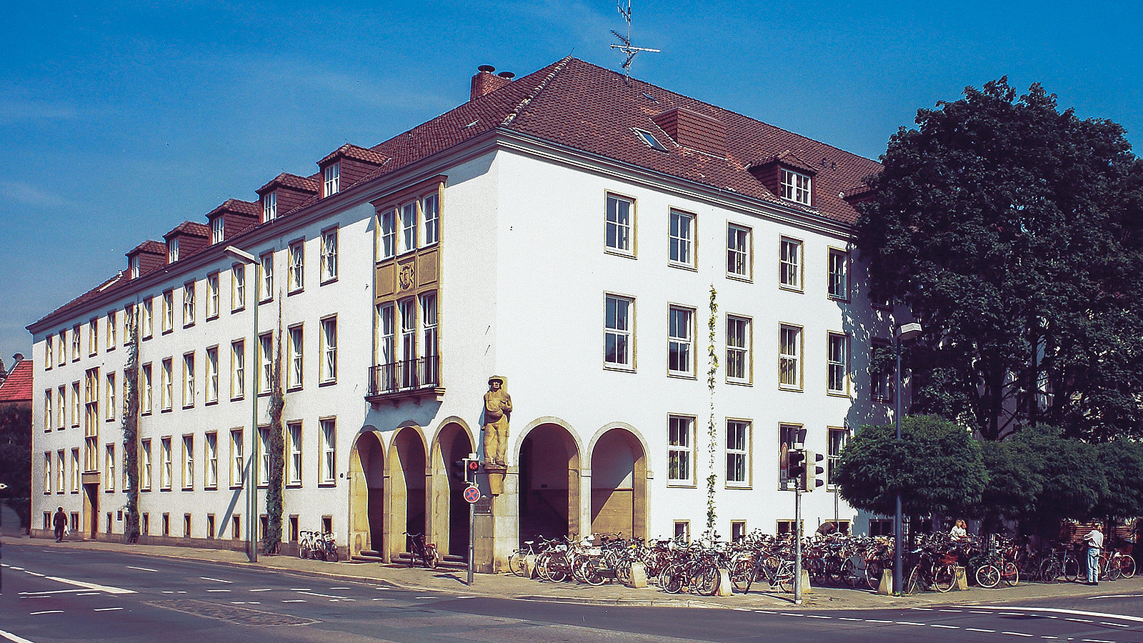 Color photo of the building with a view of the main entrance. Many bicycles are parked in front of the building