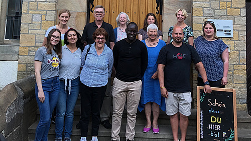 Gruppenfoto von Personen, die vor einem Steingebäude stehen.