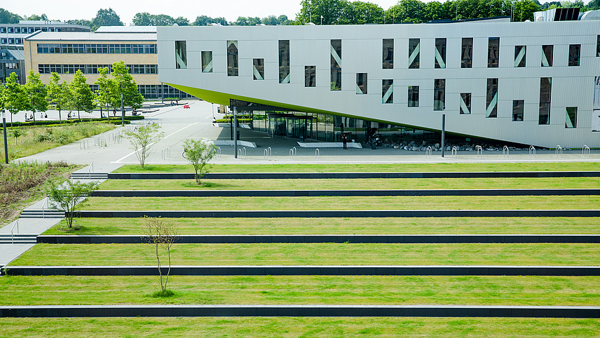 Blick aus einer der oberen Etagen in der Bibliothek am Westerberg auf den sogenannten Frosch, einem Gebäude am Campus. Davor liegt die begrünte Terasse.