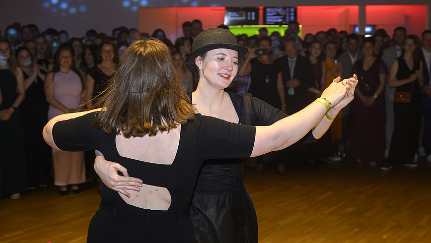 Mehrere Personen in festlicher Kleidung bei einem Ball