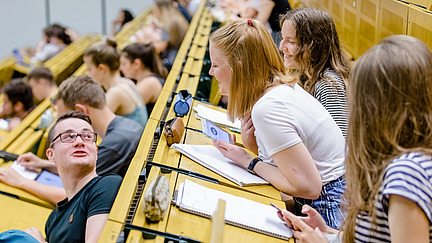 View of students across the rows of seats in a lecture hall.