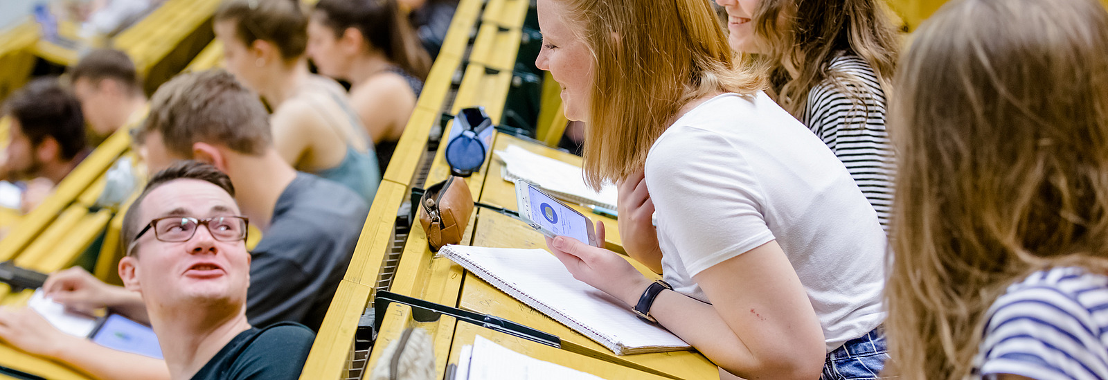 View of students across the rows of seats in a lecture hall.