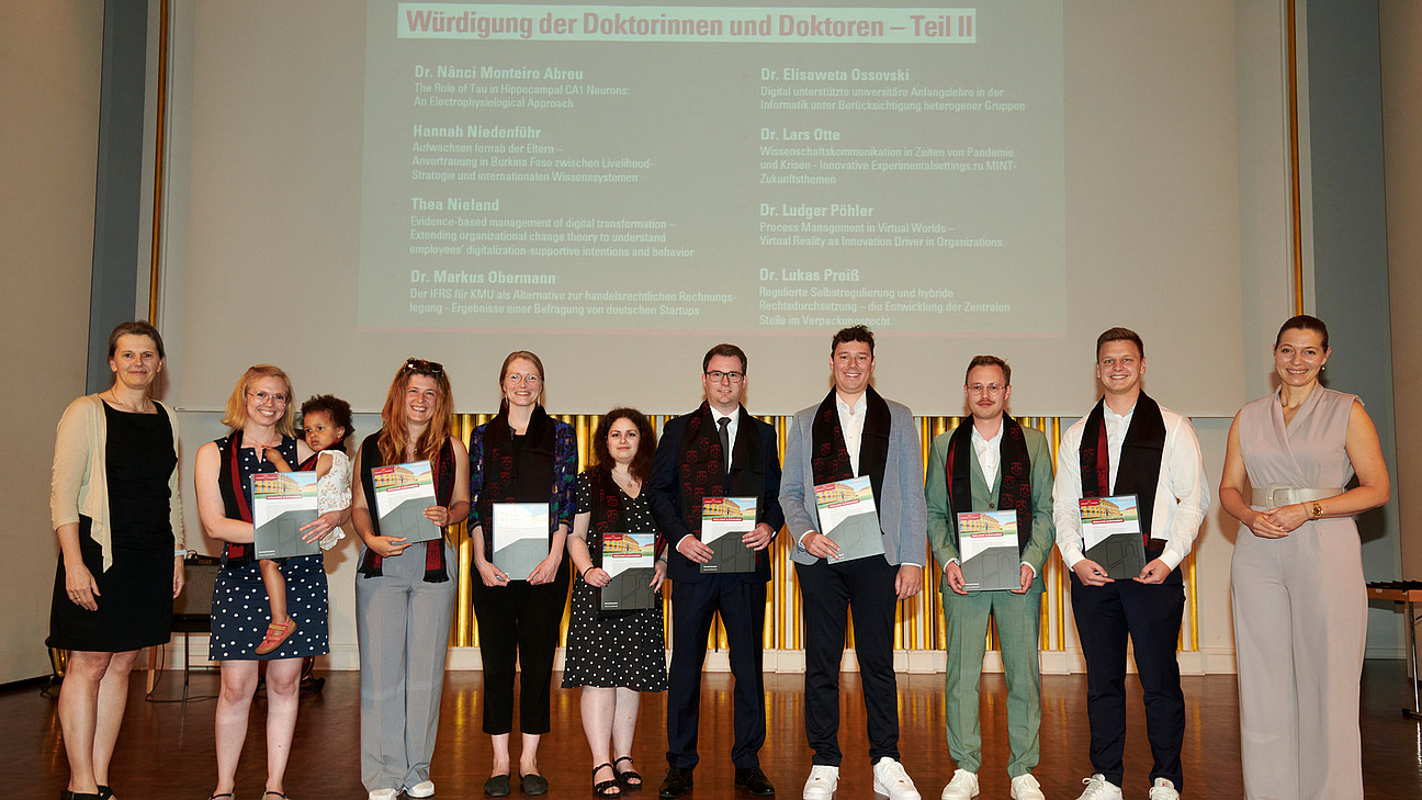 Gruppenfoto der Promovierten auf der Bühne der Schlossaula