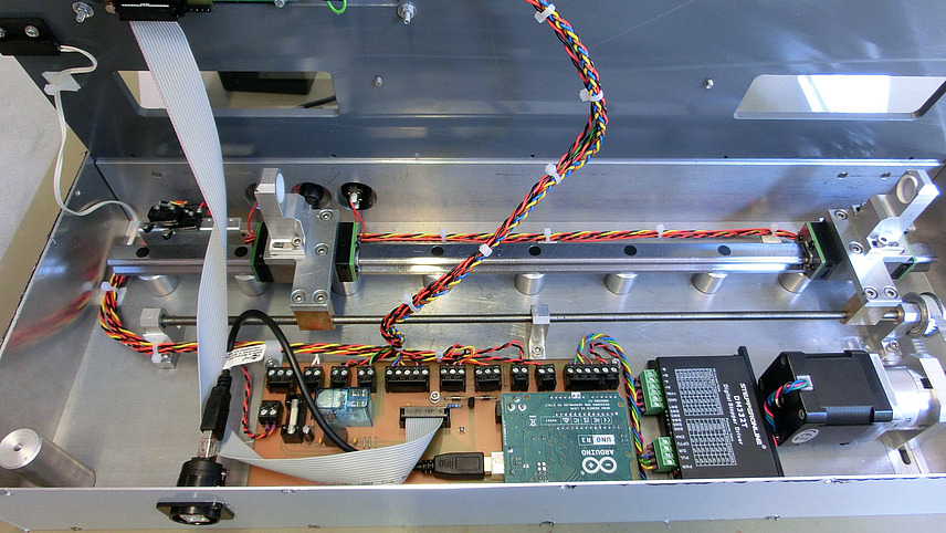 Das Bild zeigt das Innere eines metallischen Gehäuses, wahrscheinlich einer selbstgebauten Maschine oder eines Prototyps. Im Inneren sind zahlreiche elektronische Komponenten und Verkabelungen zu sehen.