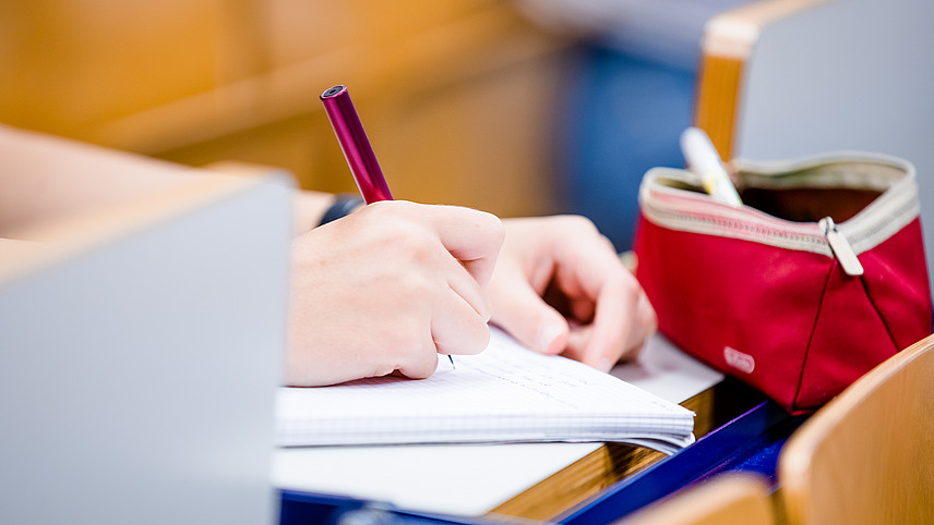 Close-up of a notepad on which a person is writing.