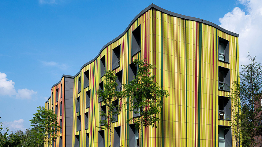 Seitenansicht des StudierQuartier im WissenschaftsPark bei Sonnenschein, wo Studierende Zimmer mieten können.