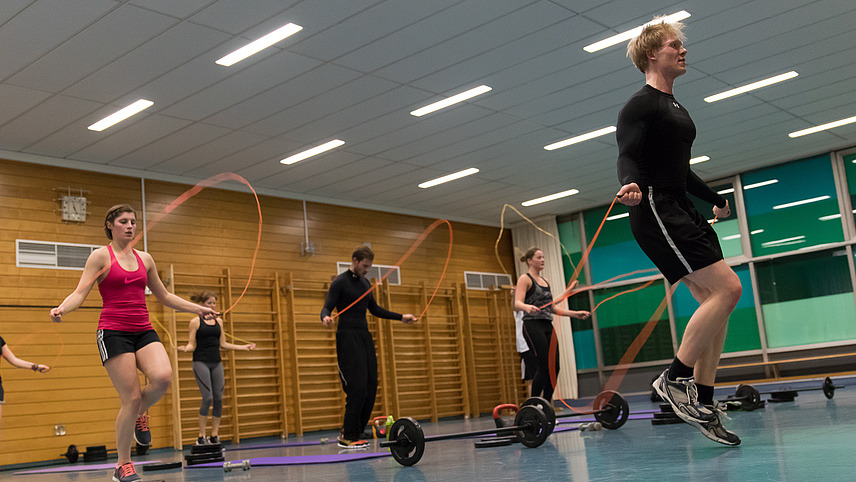 Studierende beim Seilspringen in einer Turnhalle