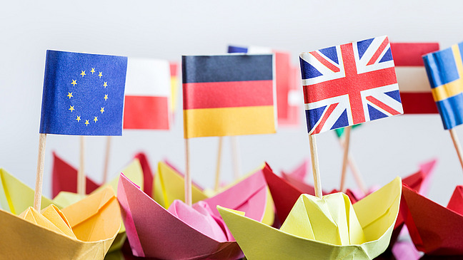 Kleine Papierschiffe mit Flaggen europäischer Staaten