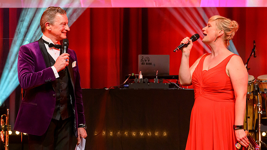 The presenters with microphone on stage