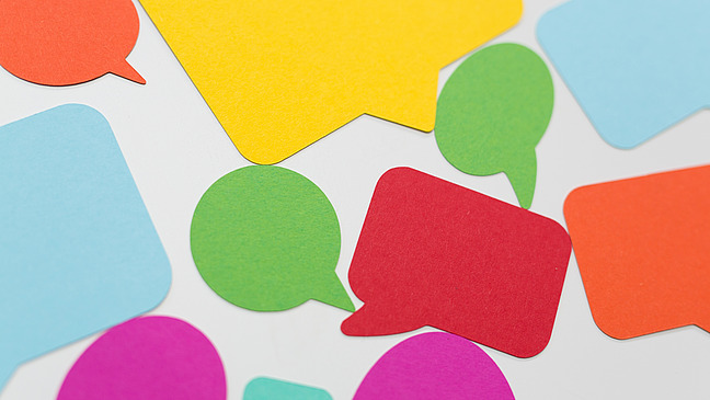 A collection of colorful paper speech bubbles in various shapes and colors, including red, blue, yellow, green and pink.