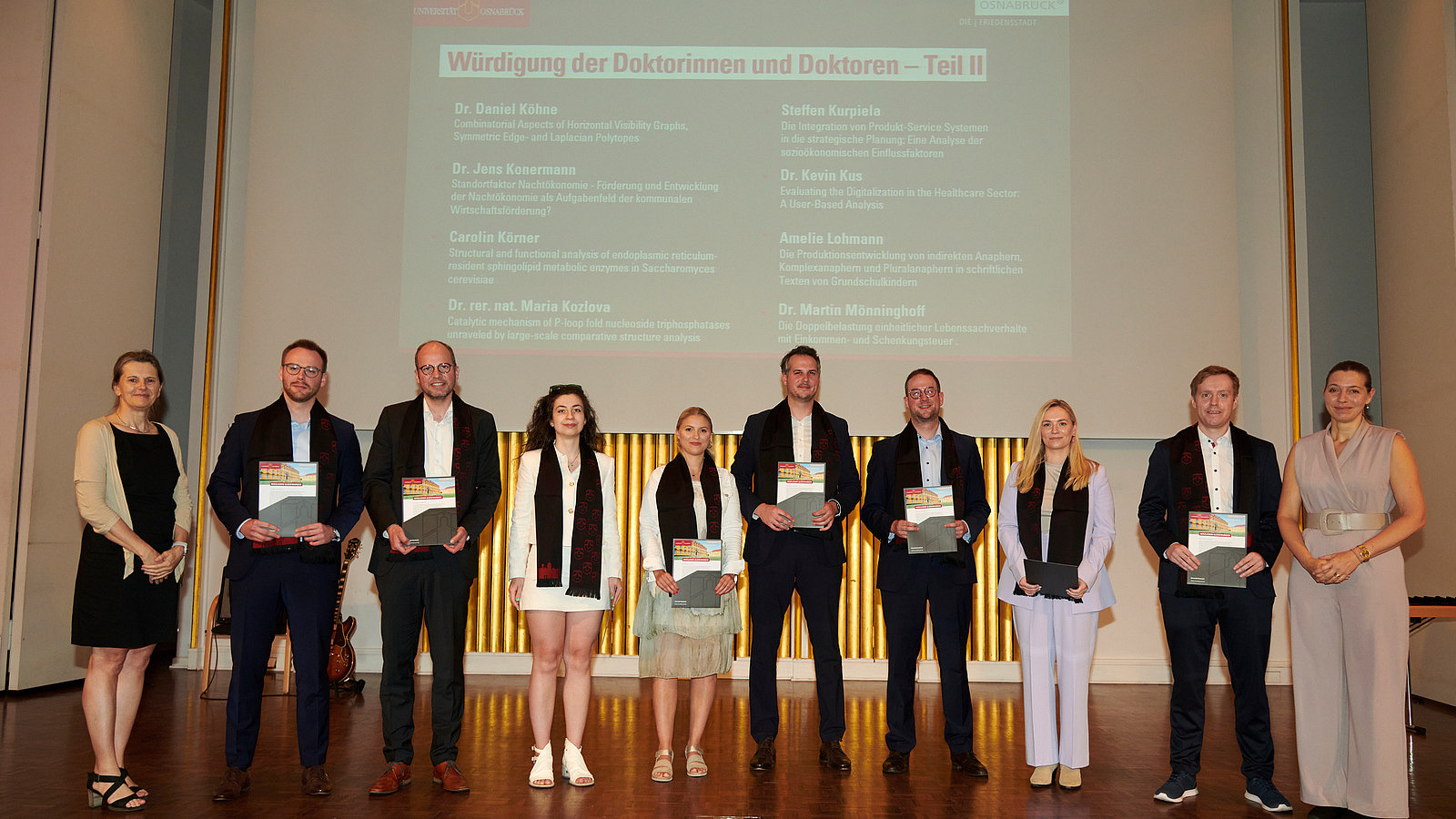 Gruppenfoto der Promovierten auf der Bühne der Schlossaula