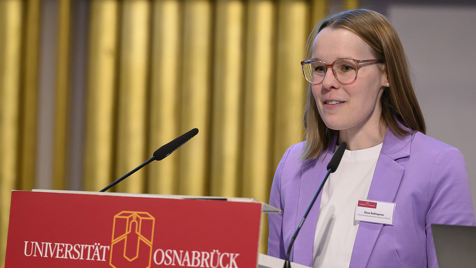 A young woman speaks at the podium.