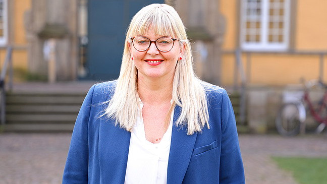 Prof. Dr. Dana Bergmann in blauem Blazer im Innenhof des Schlosses