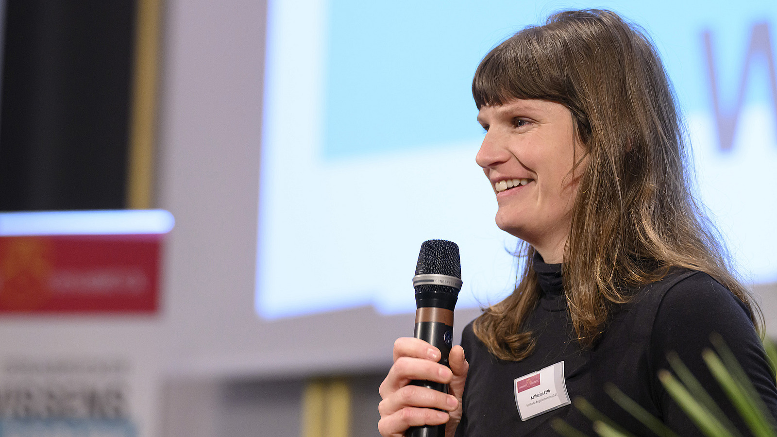 A young woman speaks into the microphone.