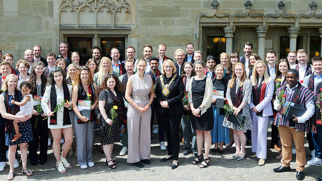 Gruppenfoto der Promovierten vor dem Osnabrücker Rathaus