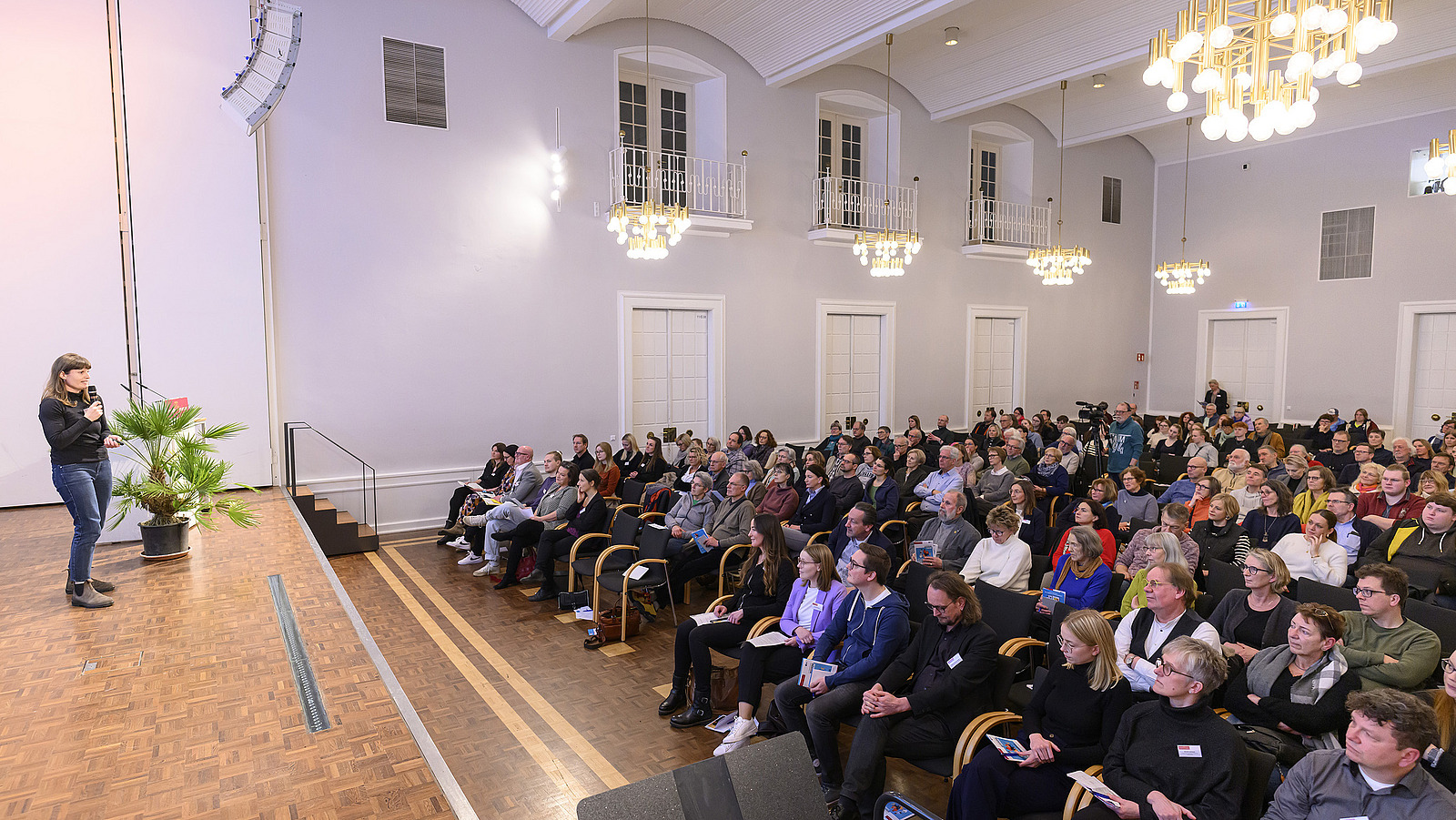 A woman speaks in front of an audience.