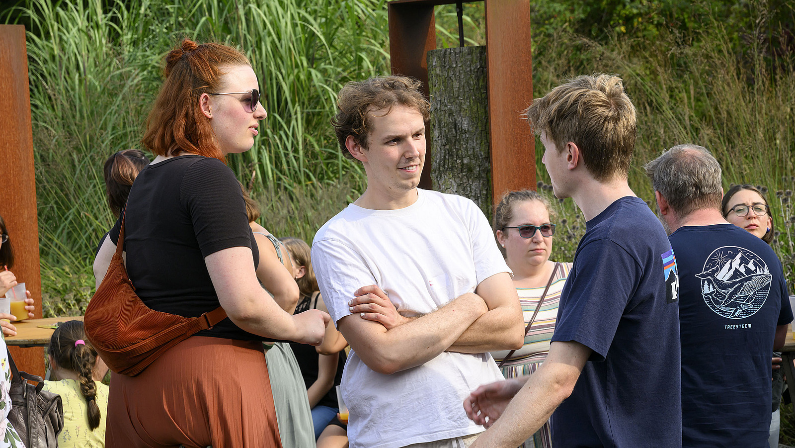 Mehrere fröhliche Personen bei einer Gartenparty.