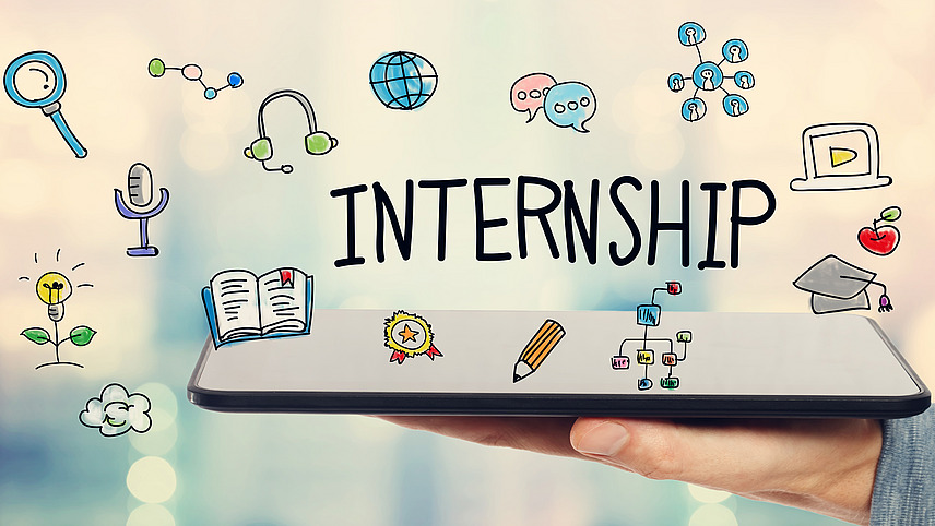 Hand holding an open book. The word “INTERNSHIP” was entered manually on the picture and icons associated with the preparation of an internship were sketched.