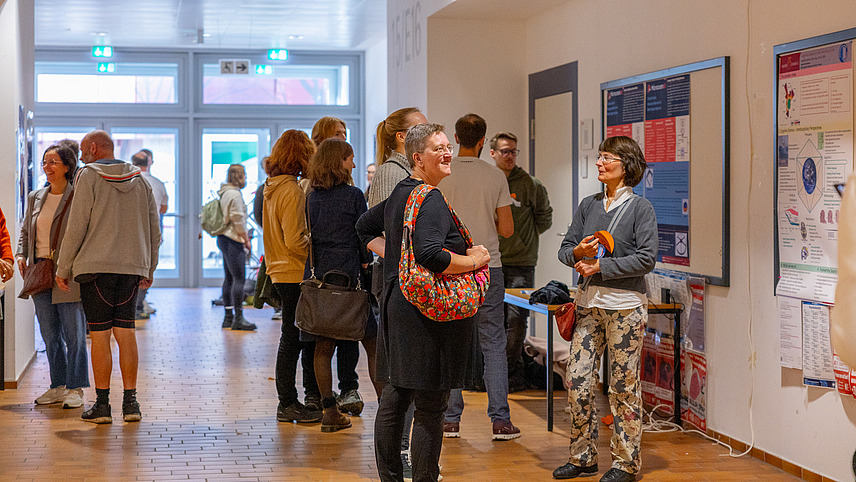 Viele Menschen in einem Flur mit Plakaten an den Wänden