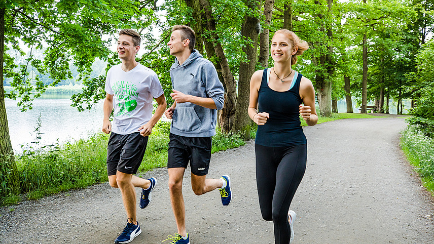 Drei Studierende joggen am Rubbenbruchsee.