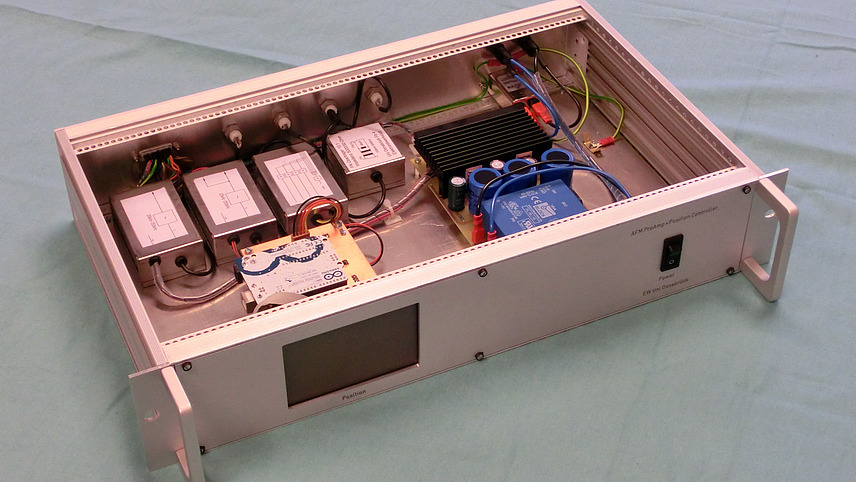 Das Bild zeigt das Innere eines metallischen Gehäuses, wahrscheinlich ein 19-Zoll-Rack-Gehäuse. Es ist von oben aufgenommen und zeigt die darin installierte Elektroni