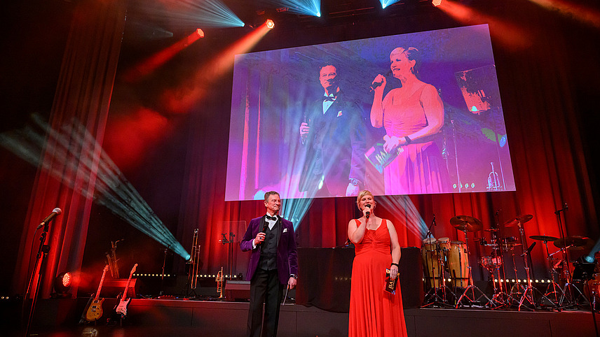 The presenters with microphone on stage