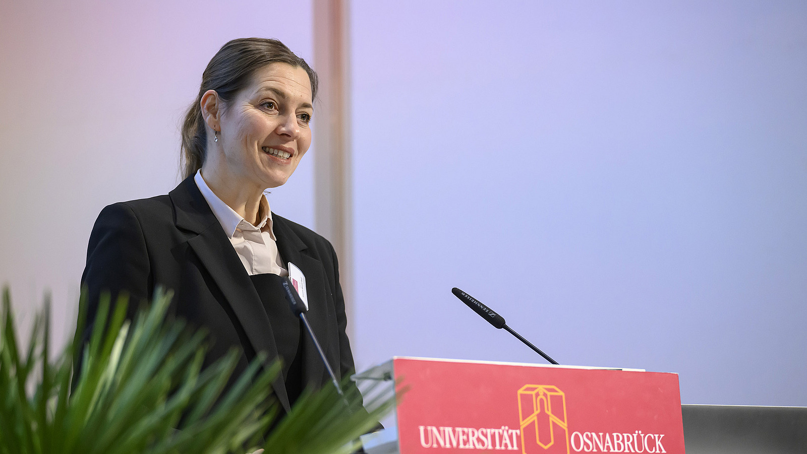 A woman stands at the podium and speaks.