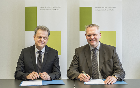 Universitätspräsident Prof. Dr. Wolfgang Lücke und Niedersachsens Wissenschaftsminister Björn Thümler unterzeichnen die Zielvereinbarung für die Universität Osnabrück.