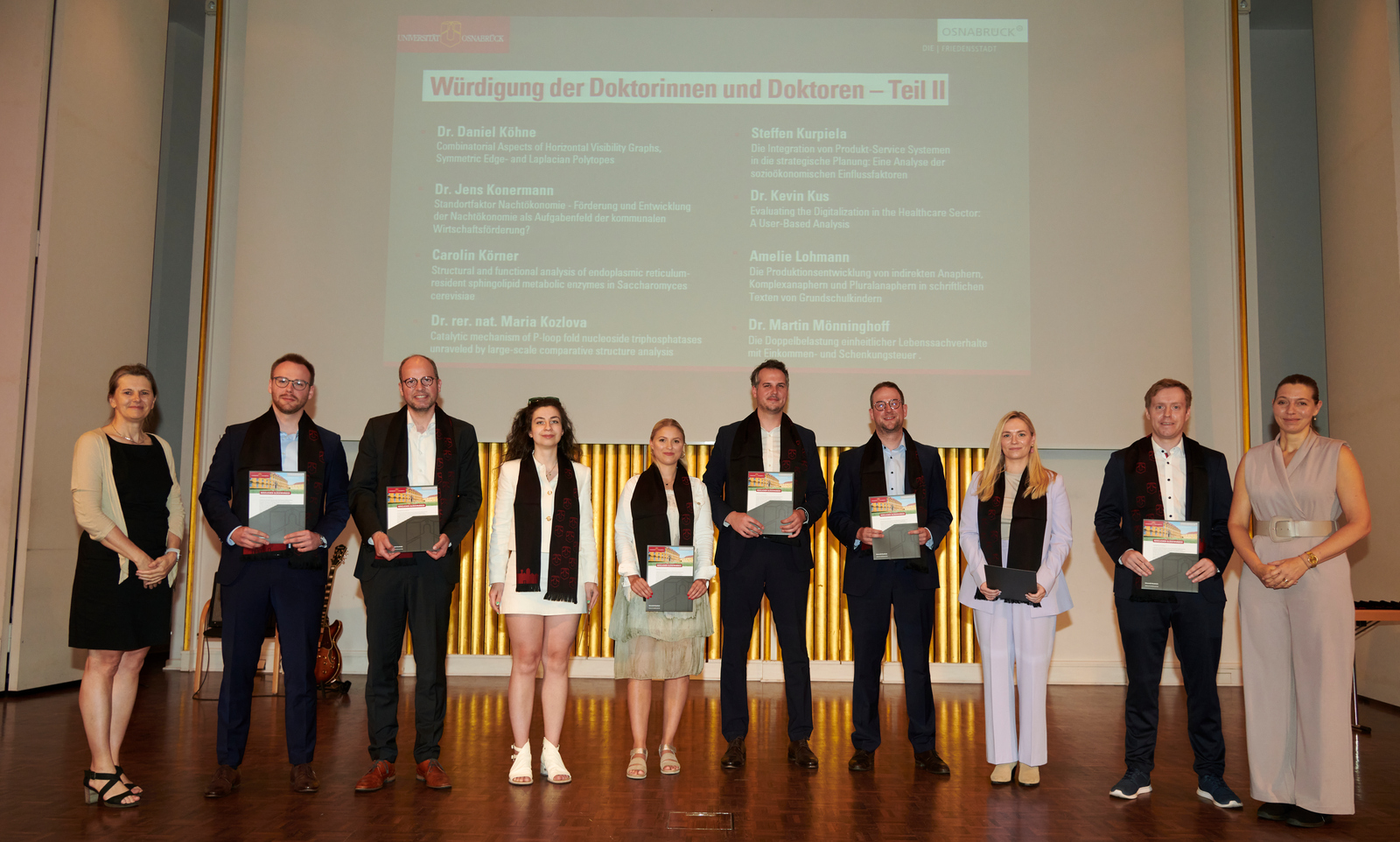 Gruppenfoto der Promovierten auf der Bühne der Schlossaula